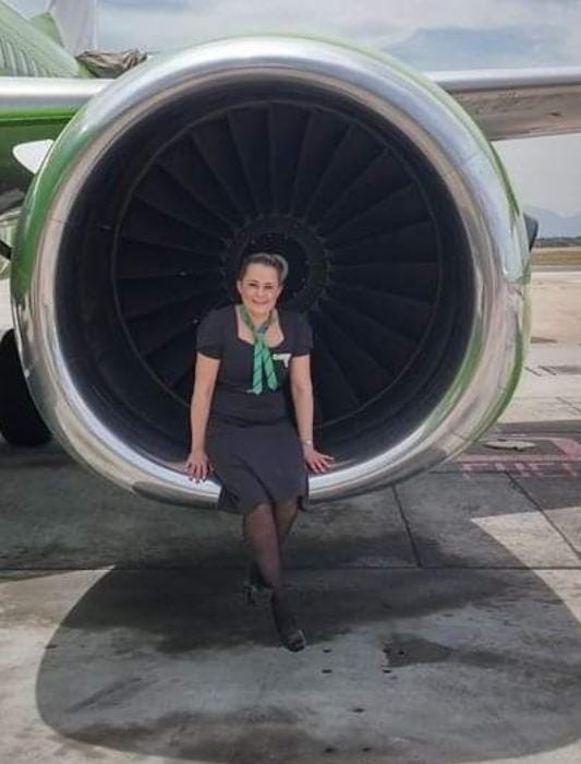 Shot of Jenna Woods next to passenger aircraft