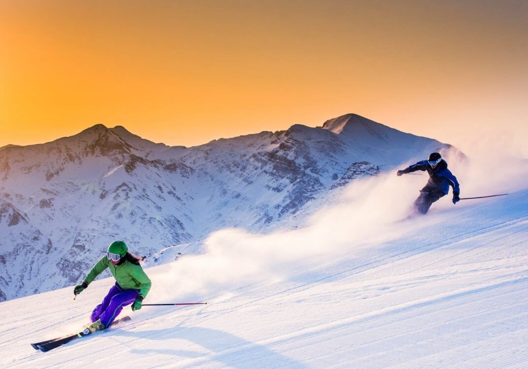 People skiing at sunset