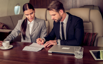 A businessman and businesswoman doing work on a private jet