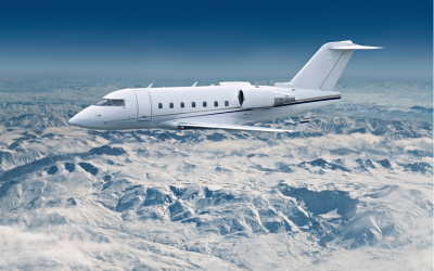 Private jet flying over snowy mountains