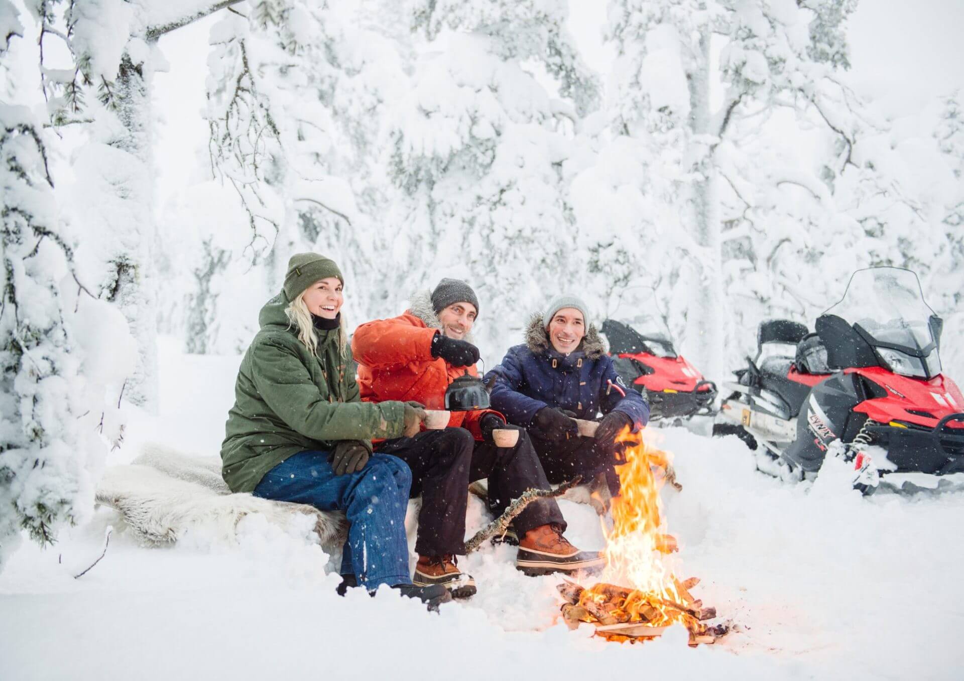 Snowmobilers around campfiire